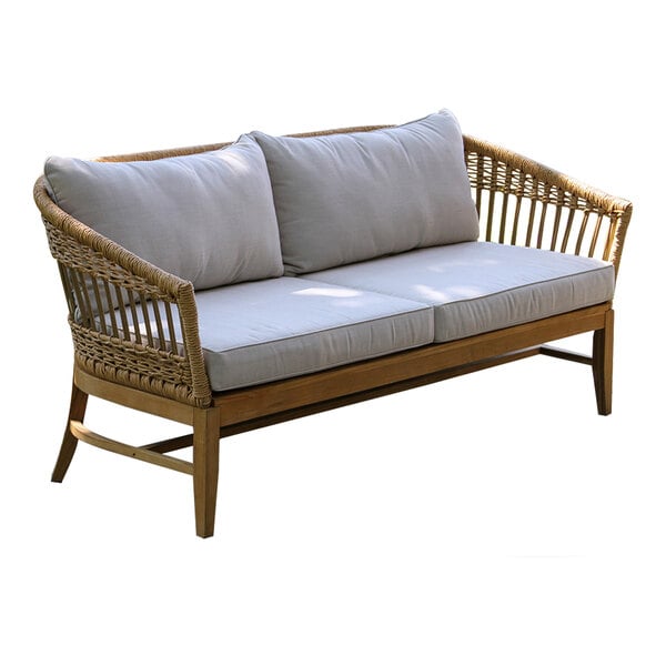 An Outdoor Interiors teak and wicker sofa with white cushions.