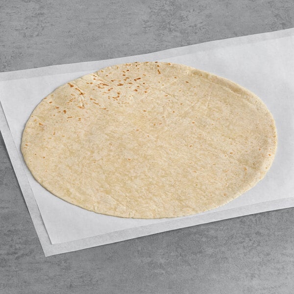 An ALTA Foods flour tortilla on a white surface.