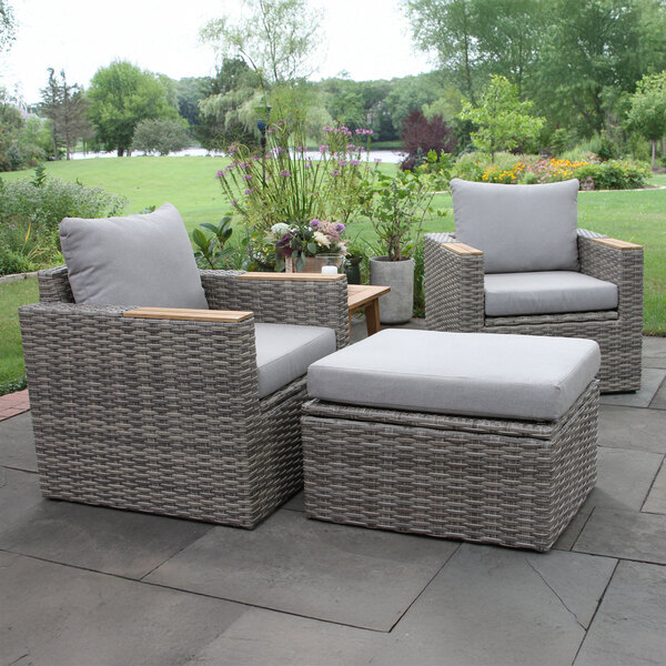An Outdoor Interiors wicker chair with a white cushion on a patio.