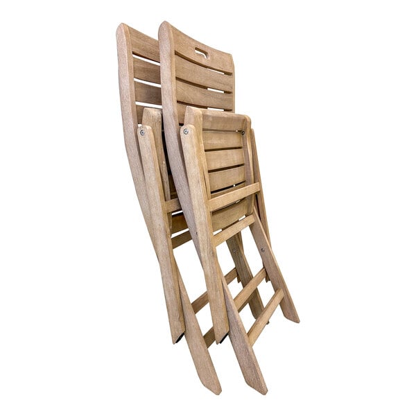 A stack of three Outdoor Interiors Antique Wash Eucalyptus Folding Armless Chairs.
