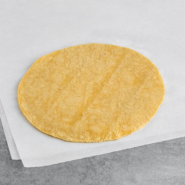 A Celia's 6" yellow corn tortilla on white paper.