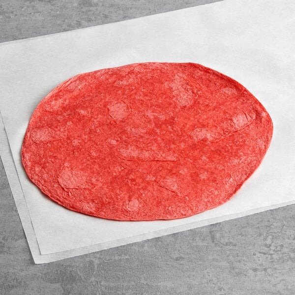 A Celia's Sun Dried Tomato Flour Tortilla on a white surface.