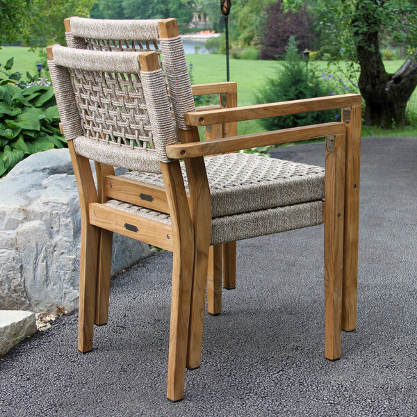 Two Outdoor Interiors teak and rope chairs on an outdoor patio.