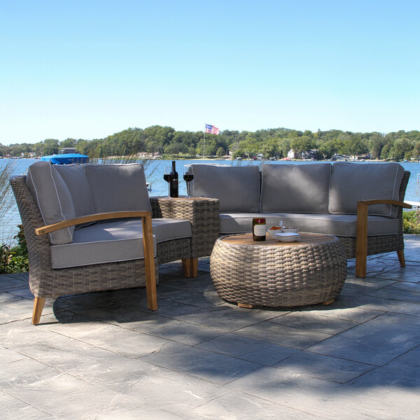 A stone patio with a round gray and brown table and chairs.