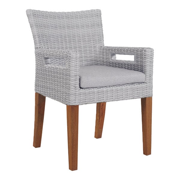 An Outdoor Interiors wicker dining arm chair with grey cushion on wooden legs.