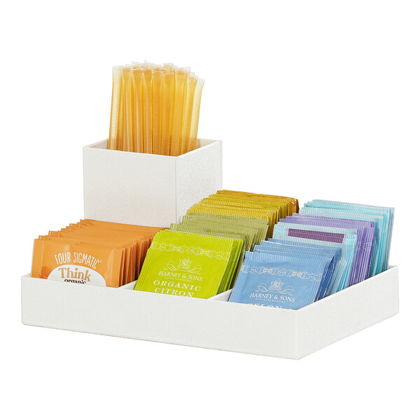 A white Cal-Mil condiment organizer with orange, green, and yellow packets inside.