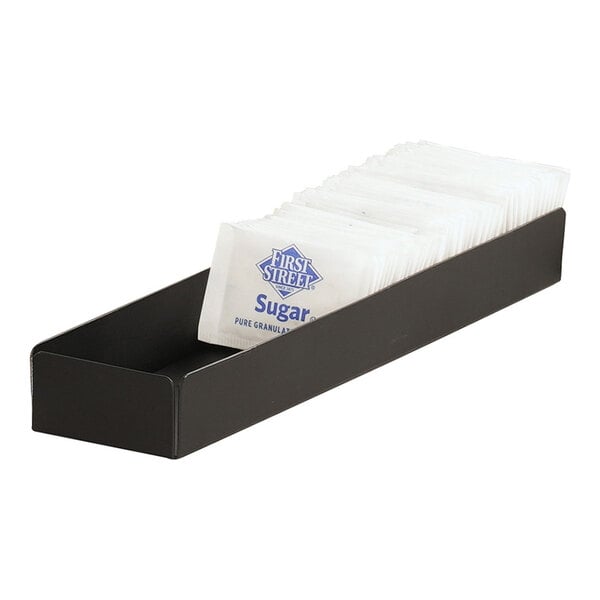 A black Cal-Mil metal container holding white sugar packets on a counter.