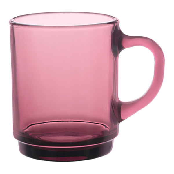 A pink glass mug with a black handle.