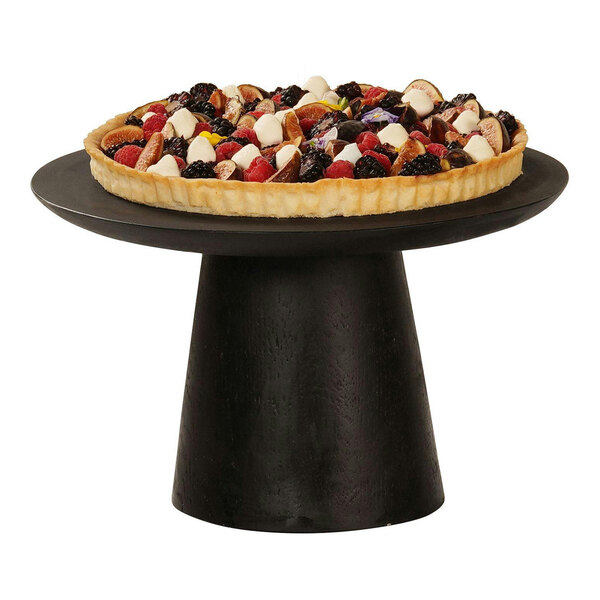 A fruit pie on a black Cal-Mil cake pedestal on a table in a bakery display.