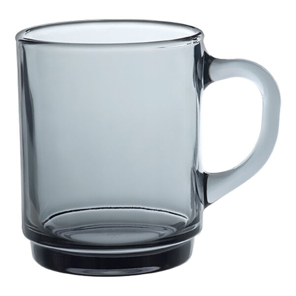 A clear Duralex glass mug with a handle.
