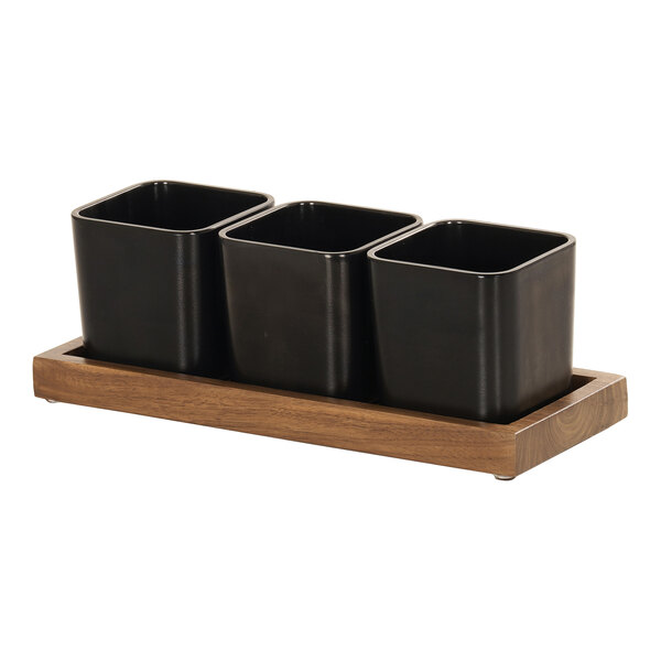 A wooden Cal-Mil condiment organizer with three black square containers.