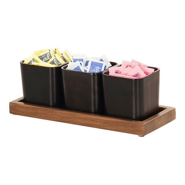 A Cal-Mil walnut condiment organizer with three black square containers inside.