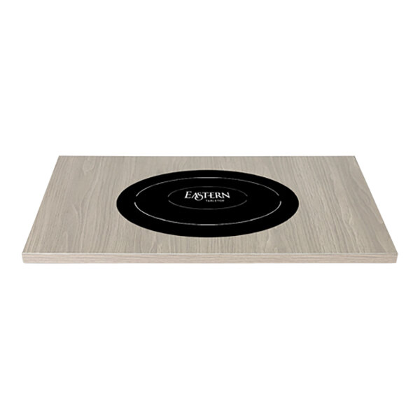 An Eastern Tabletop rectangular high-pressure laminate induction tile with a black and white oval logo on a wood surface.