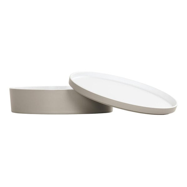 A white round melamine bento box with a lid.