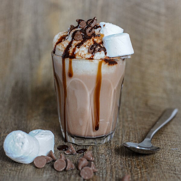 A Duralex Provence glass of hot chocolate with marshmallows and a spoon.
