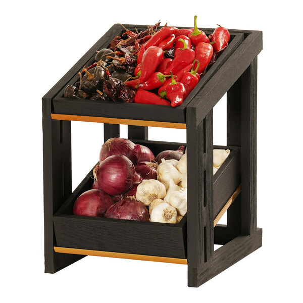 A Cal-Mil black wooden 2-tier merchandise display with onions and peppers on a shelf.