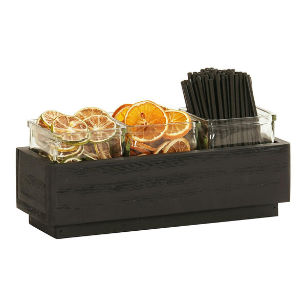 A black wood Cal-Mil jar display shelf with jars of orange slices and black straws.