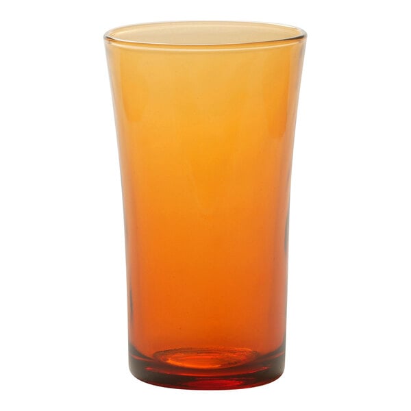 A Duralex glass with an orange rim filled with orange liquid.