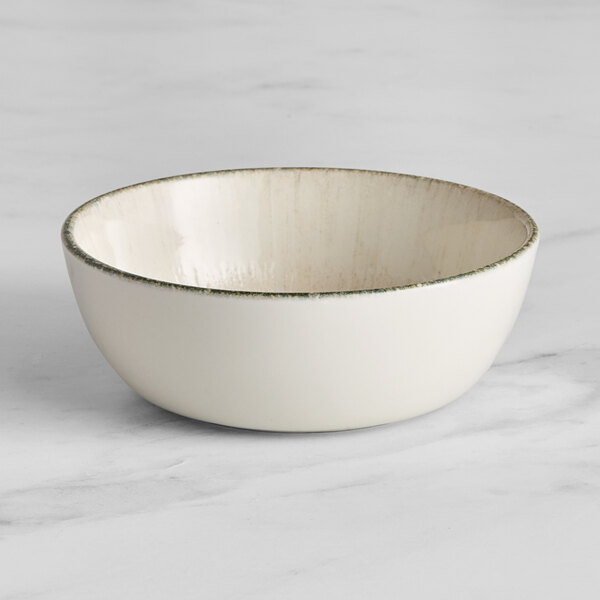 An Acopa Cape white porcelain bowl with a green rim.