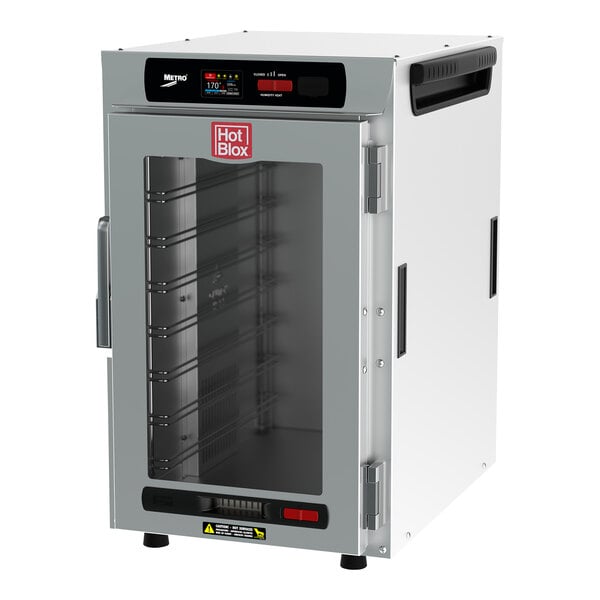 A white holding cabinet with a clear glass door holding trays.