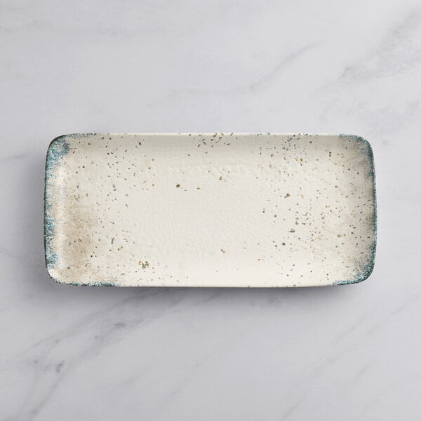 A white rectangular plate with specks.