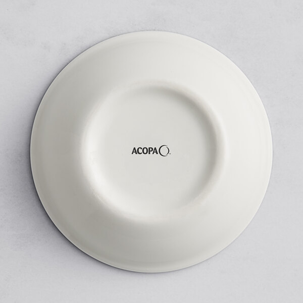 A white porcelain ramekin with the word "dama" in black text.