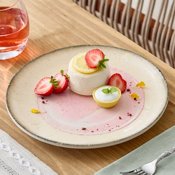 A round gray porcelain coupe plate with a dessert and fruit garnish.