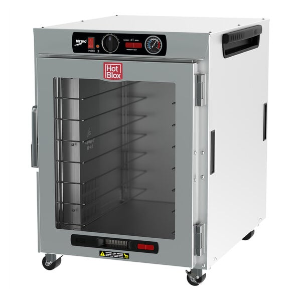 A white Metro heated holding cabinet with a clear glass door holding trays.