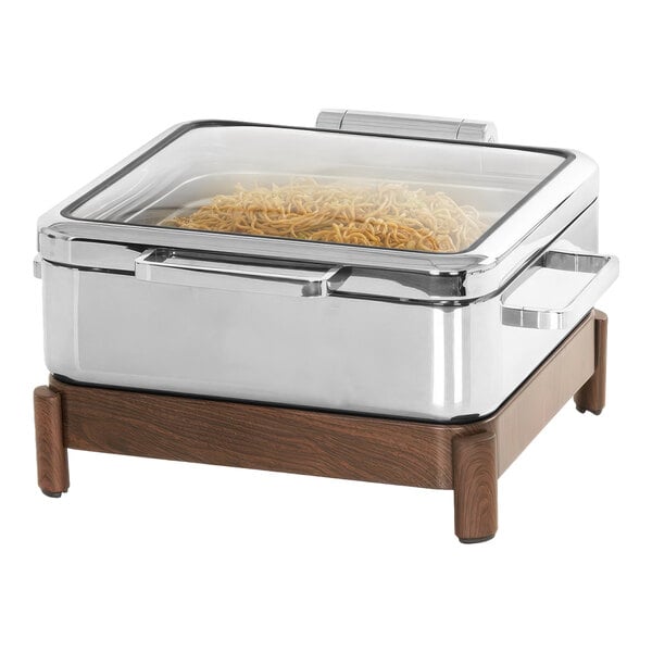A stainless steel chafer with food in a container on a table.