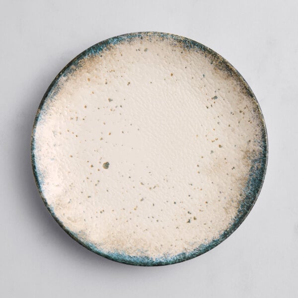 An Acopa round porcelain coupe plate with a white and blue speckled design.