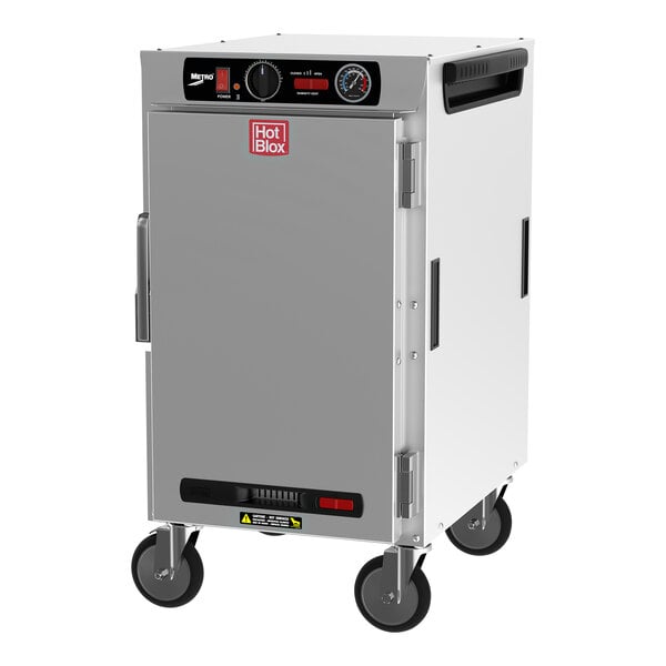 A large silver rectangular Metro heated holding cabinet with wheels and a solid door.