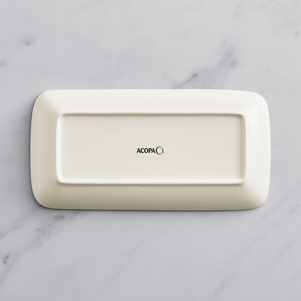 A rectangular beige Acopa Cape porcelain platter with black text on it.