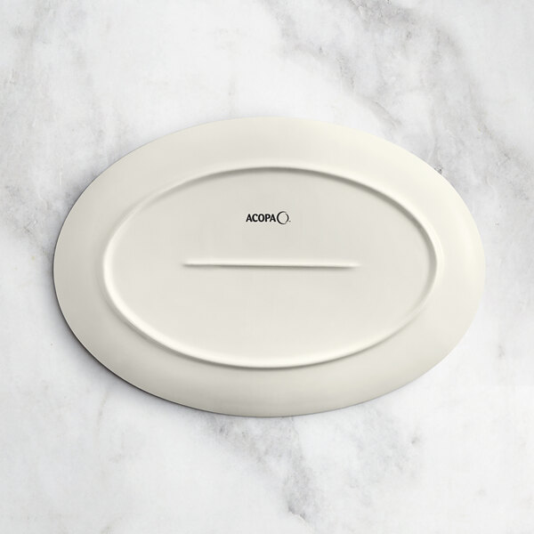 An Acopa Architect gray porcelain oval platter on a marble surface.