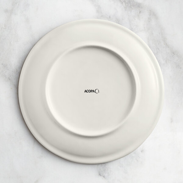 A beige Acopa Cape porcelain coupe plate with a circular design.