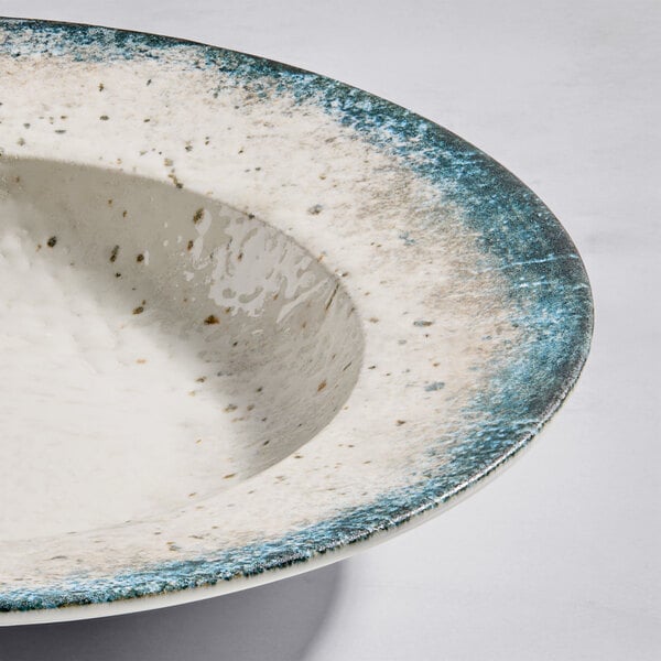 A round gray porcelain wide rim bowl with a speckled design and blue-gray edge.