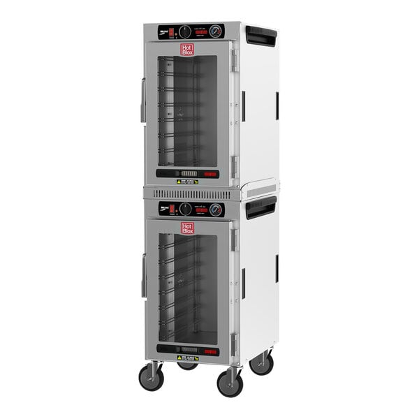 A white Metro heated holding cabinet with clear glass doors on wheels.