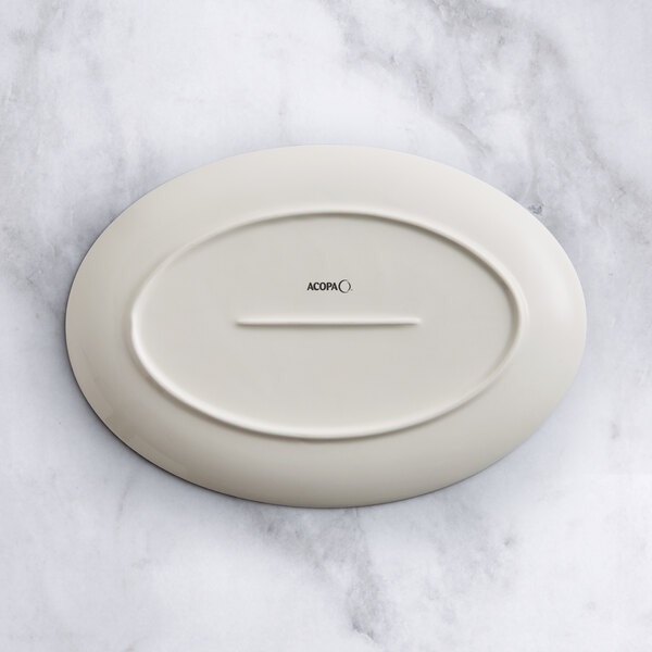 An oval gray porcelain platter with a white oval on it.