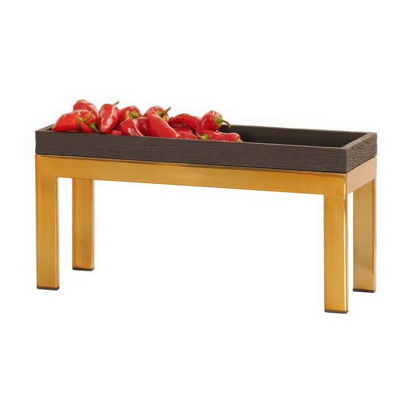 A Cal-Mil brass metal display riser holding a tray of red peppers.