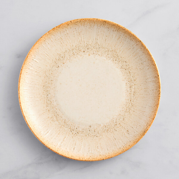 An Acopa Cape beige porcelain coupe plate with a brown rim.