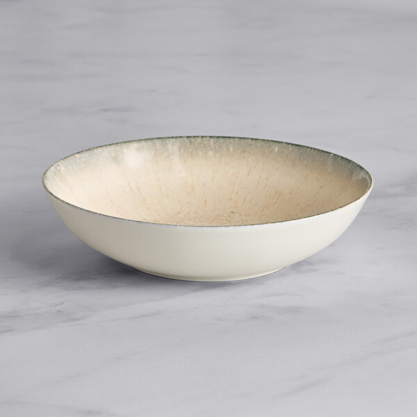 An Acopa Cape porcelain deep coupe plate with a gray rim.