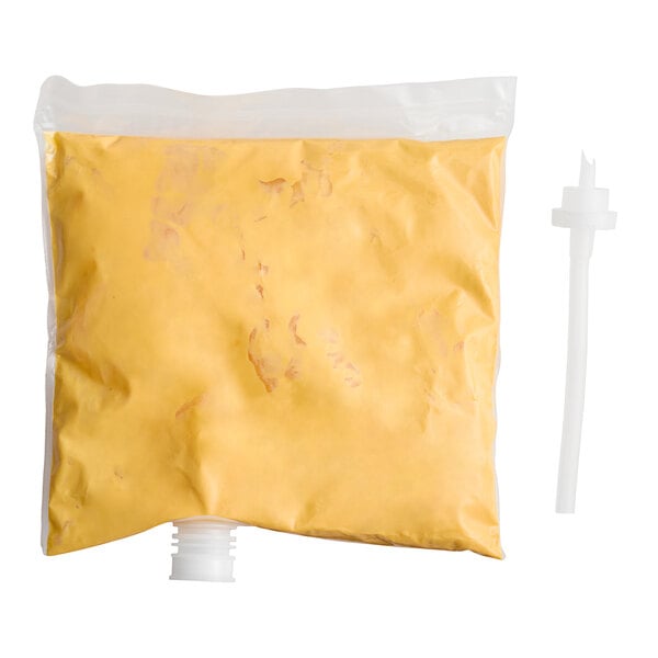 A white bag with a yellow and white label that says "Gehl's Sharp Cheddar Cheese Sauce" and a yellow cap.
