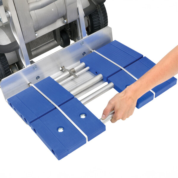 A blue and silver snap-on toe plate attachment being installed on a piece of industrial equipment.