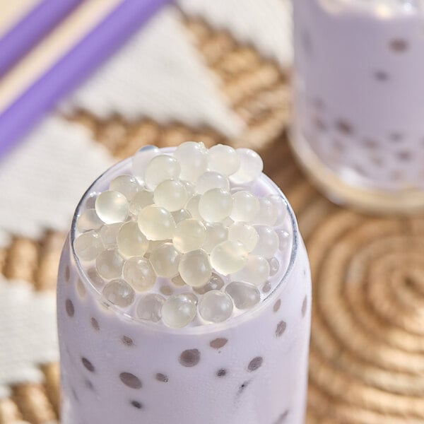 A glass of milk with Bossen Pure25 Lychee Bursting Boba in it.