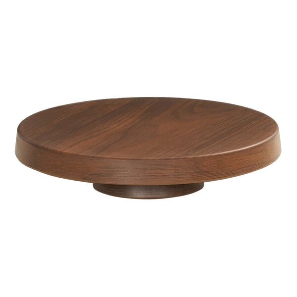 A Cal-Mil round walnut melamine cake pedestal on a wood table.