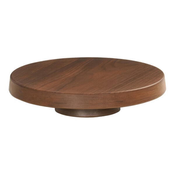 A Cal-Mil round walnut melamine cake pedestal on a wooden table.