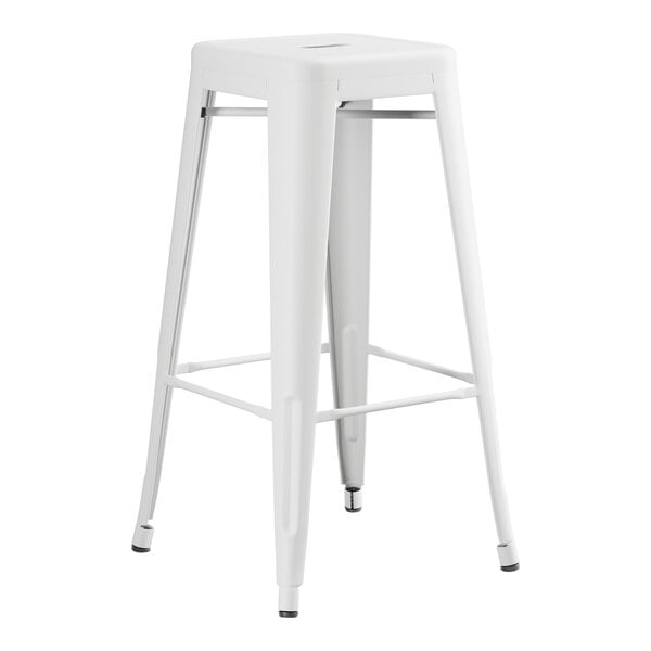 A white metal backless barstool with a metal base.