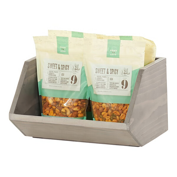 A wooden counter display with bags of nuts and dried fruit.