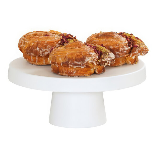 A group of pastries on a white Cal-Mil cake pedestal.