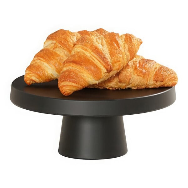A group of croissants on a black Cal-Mil round cake pedestal.