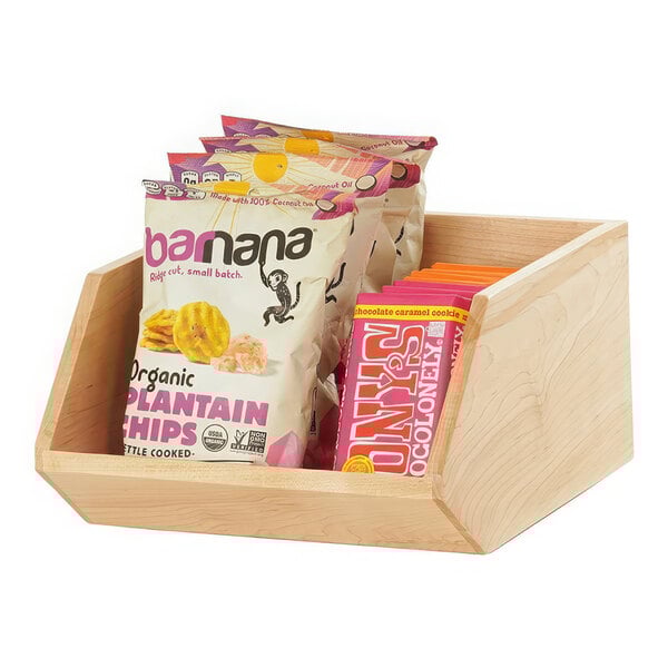 A wooden counter display with bags of snacks inside.